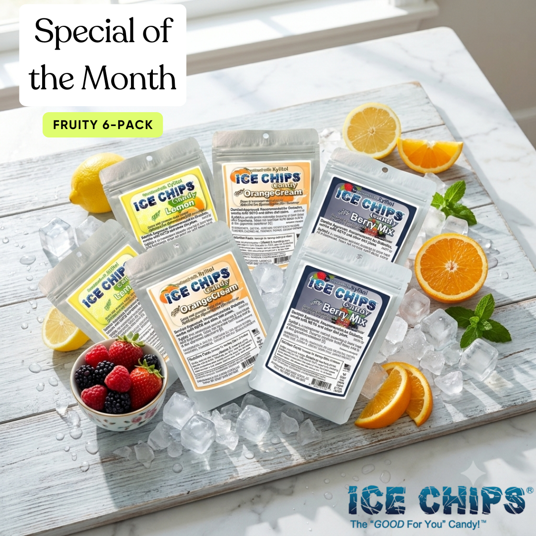 A 6-pack of ICE CHIPS candy in assorted fruit flavors, displayed on a white wooden board with ice, sliced oranges, lemons, and a small bowl of berries. The packaging features colorful labels for Orange Cream, Cranberry Cheeky, Berry Milk, and Lemonade.