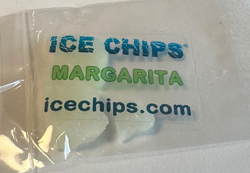 A clear plastic bag containing ice chips, with a printed label reading 'ICE CHIPS MARGARITA icechips.com' in blue and green text.