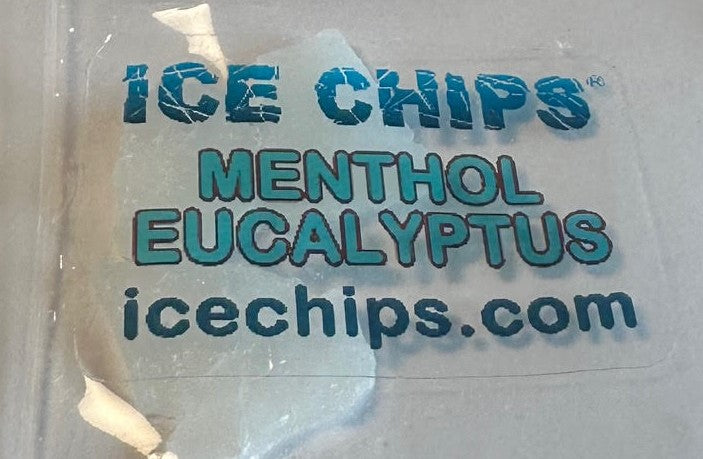 A close-up of a clear plastic bag containing ice chips, with a printed label reading 'ICE CHIPS MENTHOL EUCALYPTUS icechips.com' in blue and dark gray text.