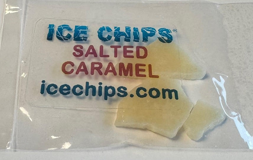 A clear plastic bag containing several pale yellow ice chips with printed text reading 'ICE CHIPS', 'SALTED CARAMEL', and 'icechips.com' on a white background.