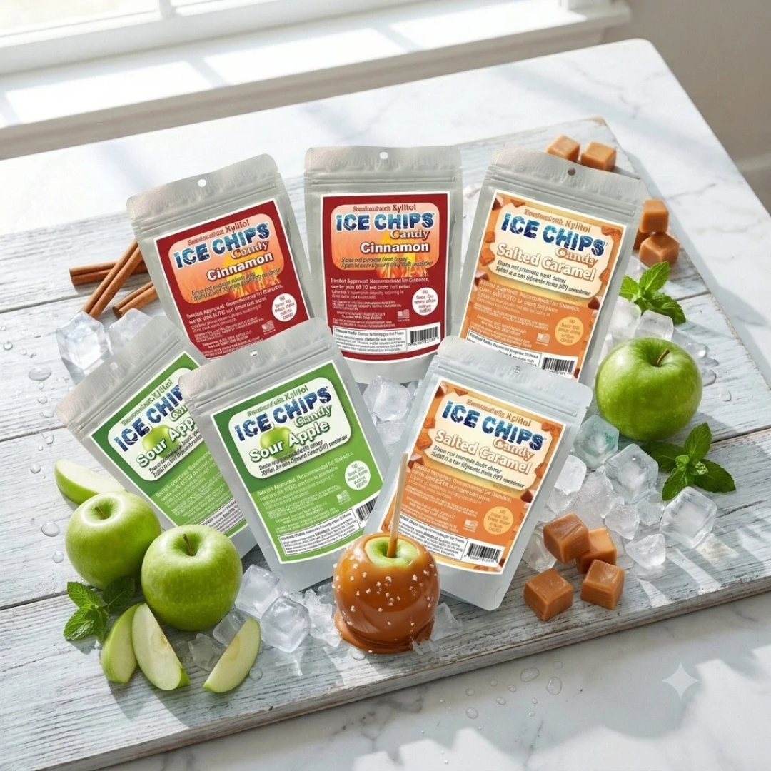 Three flavors of Ice Chips Candy — Cinnamon, Sour Apple, and Salted Caramel — arranged on a marble table with ice cubes, fresh green apples, cinnamon sticks, caramel cubes, and a caramel apple garnish