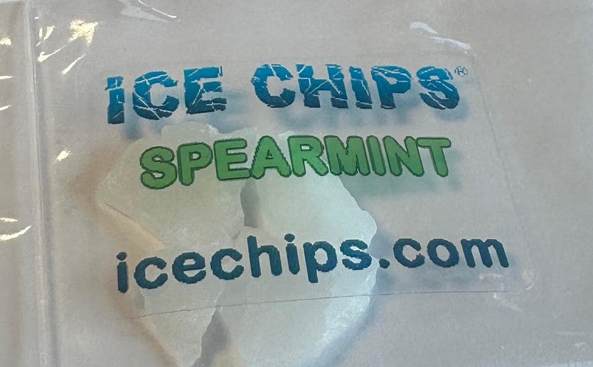A clear plastic bag containing ice chips, with the words 'ICE CHIPS SPEARMINT' printed on the front in blue and green, and 'icechips.com' below.