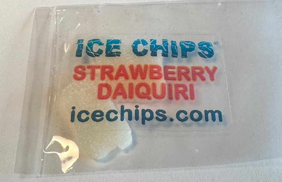 A clear plastic bag containing ice chips, with a printed label reading 'ICE CHIPS', 'STRAWBERRY DAIQUIRI', and 'icechips.com' in blue and red text.