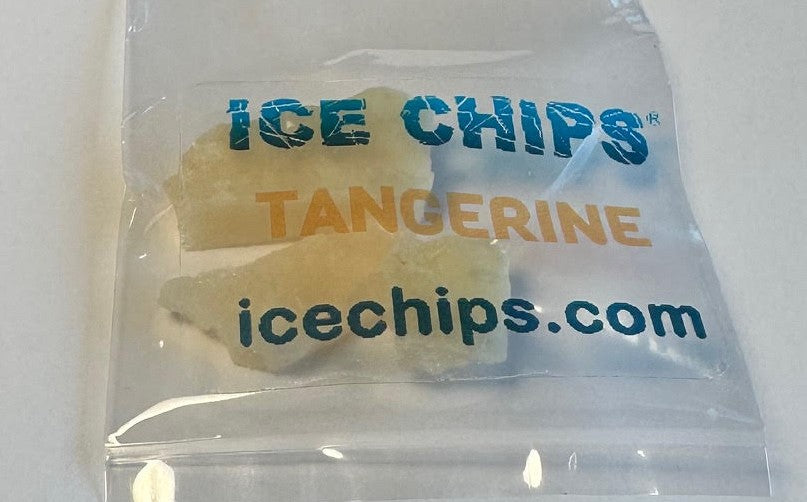 A clear plastic bag containing ice chips, with printed text reading 'ICE CHIPS', 'TANGERINE', and 'icechips.com' in blue and orange lettering.