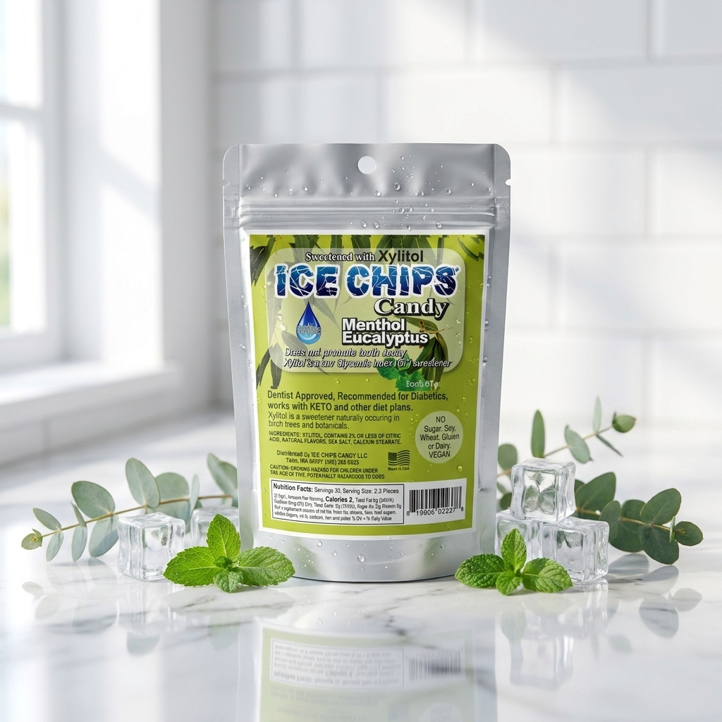 A stand-up pouch of Ice Chips Candy Menthol Eucalyptus flavor, styled on a reflective white surface with mint leaves, eucalyptus sprigs, and clear ice cubes against a bright, softly blurred kitchen background.