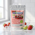 A stand-up pouch of Ice Chips Candy Strawberry Daiquiri flavor, displayed on a reflective white surface with fresh strawberries, lime wedges, and clear ice cubes around it. The background is a bright, softly blurred kitchen or studio setting with white subway tiles.