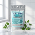 A stand-up pouch of Xylitol Ice Chips Candy Wintergreen, styled with green leaves and clear ice cubes on a reflective white surface against a bright, softly blurred background.